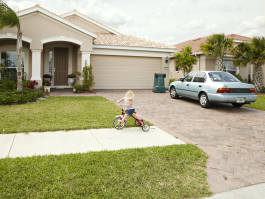 Child on tricycle outside home 