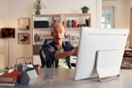 Bald man with closed eyes at oversized tablet 
