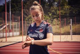Giulia Gwinn checking Apple Watch on track 