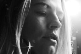 A close-up black and white image of a Hedvig Wessel Free ski World Chamption face in soft focus, with hair partially visible, creating an introspective mood. 