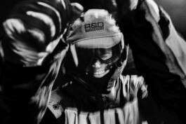 A smiling Hedvig Wessel Free ski World Chamption in skiing gear covered in water droplets, wearing goggles and a cap with 